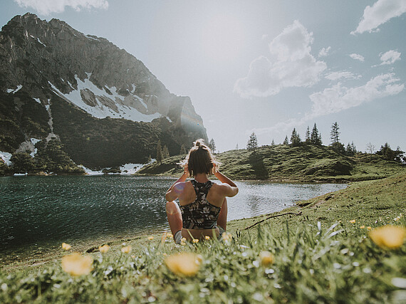 Frau auf Bergwiese an See mit Bergblick - Alpsee Camping Immenstadt