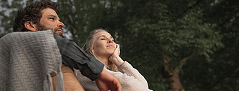 Paar sitzt vor Bäumen - Alpsee Camping Immenstadt