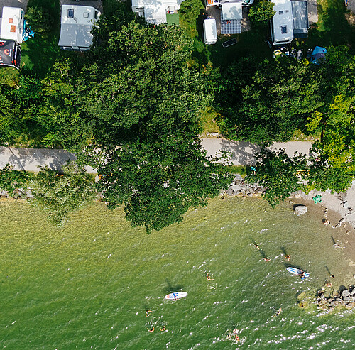 drohnenaufnahme campingplatz mit seezugang