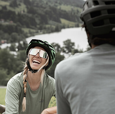 Bikerin lacht Mann an - Alpsee Camping Immenstadt