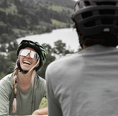 Bikerin lacht Mann an - Alpsee Camping Immenstadt