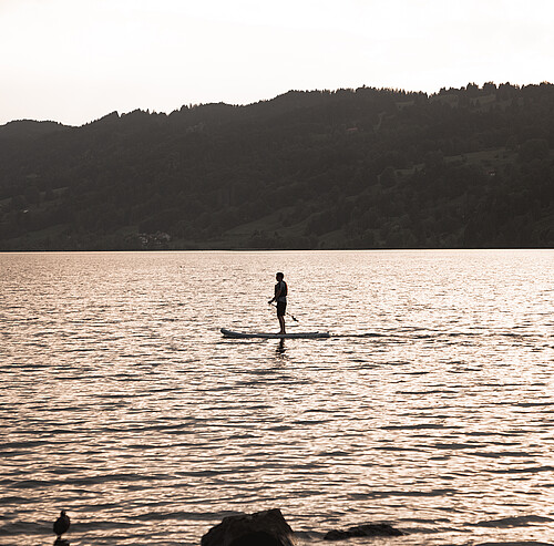 Alpsee Camping Allgäu | Person auf Stand-Up Paddle Board auf dem Alpsee im Allgäu