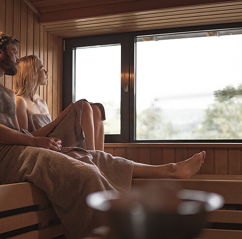 Paar in Sauna blickt aus dem Fenster - Alpsee Camping Immenstadt im Allgäu