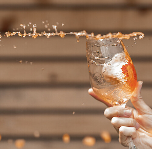 Hand schwenkt Aperolglas - Alpsee Camping Immenstadt