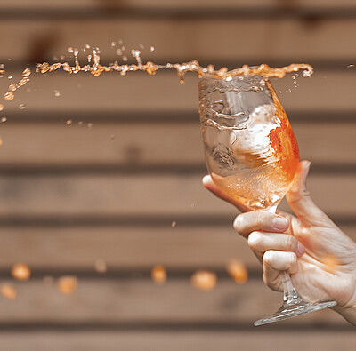 Hand schwenkt Aperolglas - Alpsee Camping Immenstadt