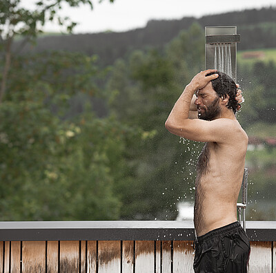 Mann unter Außendusche - Alpsee Camping Immenstadt