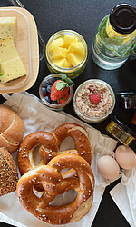 Frühstückskorb beim Alpsee Camping mit Brötchen, Wurst, Käse, Eiern, diversen Aufstrichen, Saft und Müsli