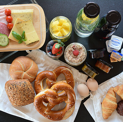 Frühstückskorb beim Alpsee Camping mit Brötchen, Wurst, Käse, Eiern, diversen Aufstrichen, Saft und Müsli